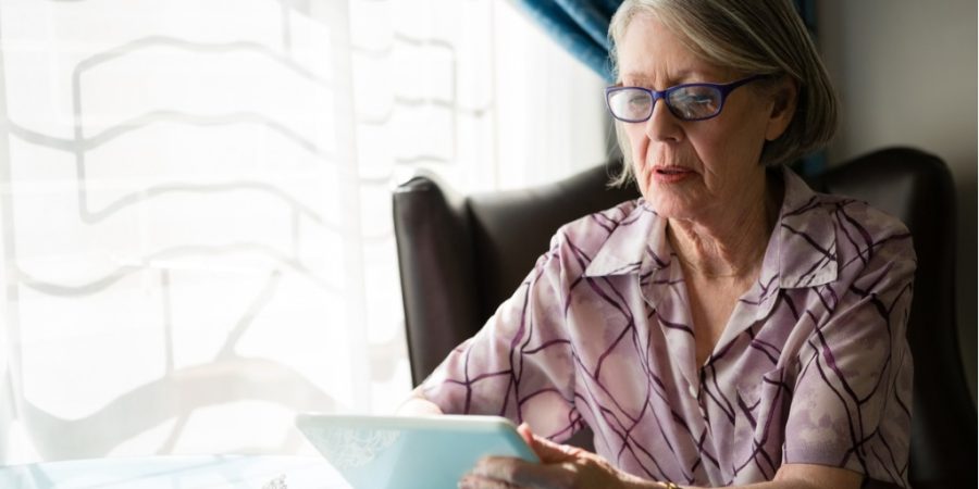 Care home resident using computer tablet.