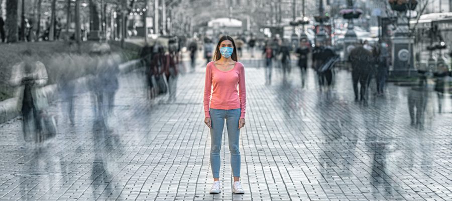 Woman with medical mask in crowded street