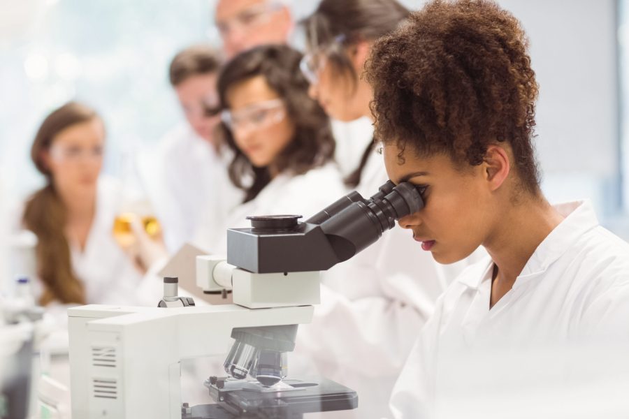 Science student looking through microscope in a laboratory